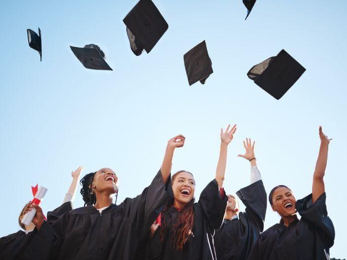 graduates throwing their caps in the air.
